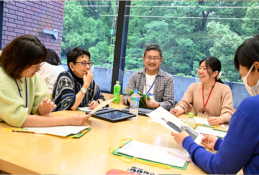 窓辺のテーブルで笑顔で話し合うとびラーたち